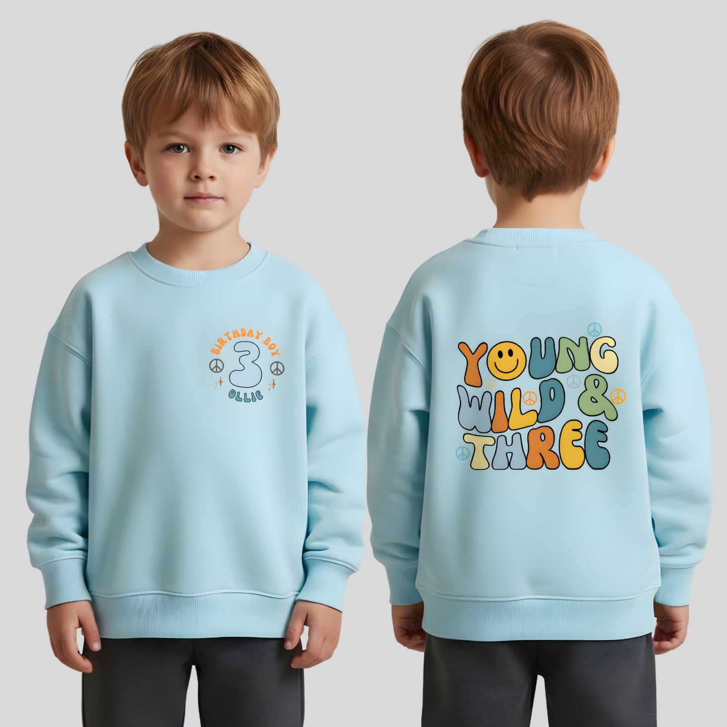 Personalised Young Wild and three birthday sweatshirt: A boys birthday sweatshirt with a Young Wild and Three theme, showcasing a groovy retro style. The front features whimsical retro emojis and the words birthday boy alongside a custom name on the left breast. The back displays bold retro fonts and graphics. Tthis vibrant and playful tee is designed for comfort and style, perfect for third birthday gifts.