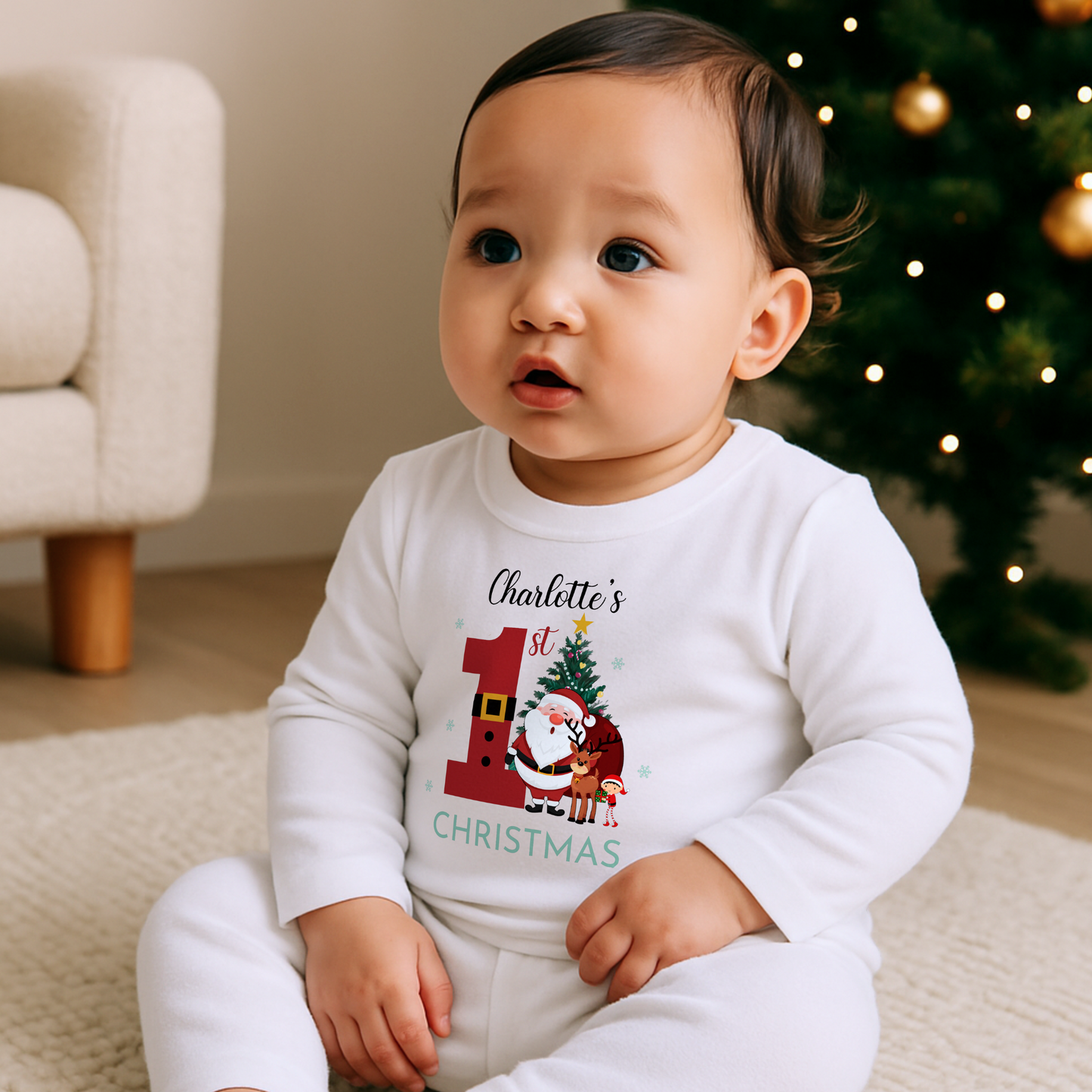 First Christmas Pyjamas, Baby wearing personalized white 1st Christmas pyjamas with festive Santa and reindeer design by Christmas tree