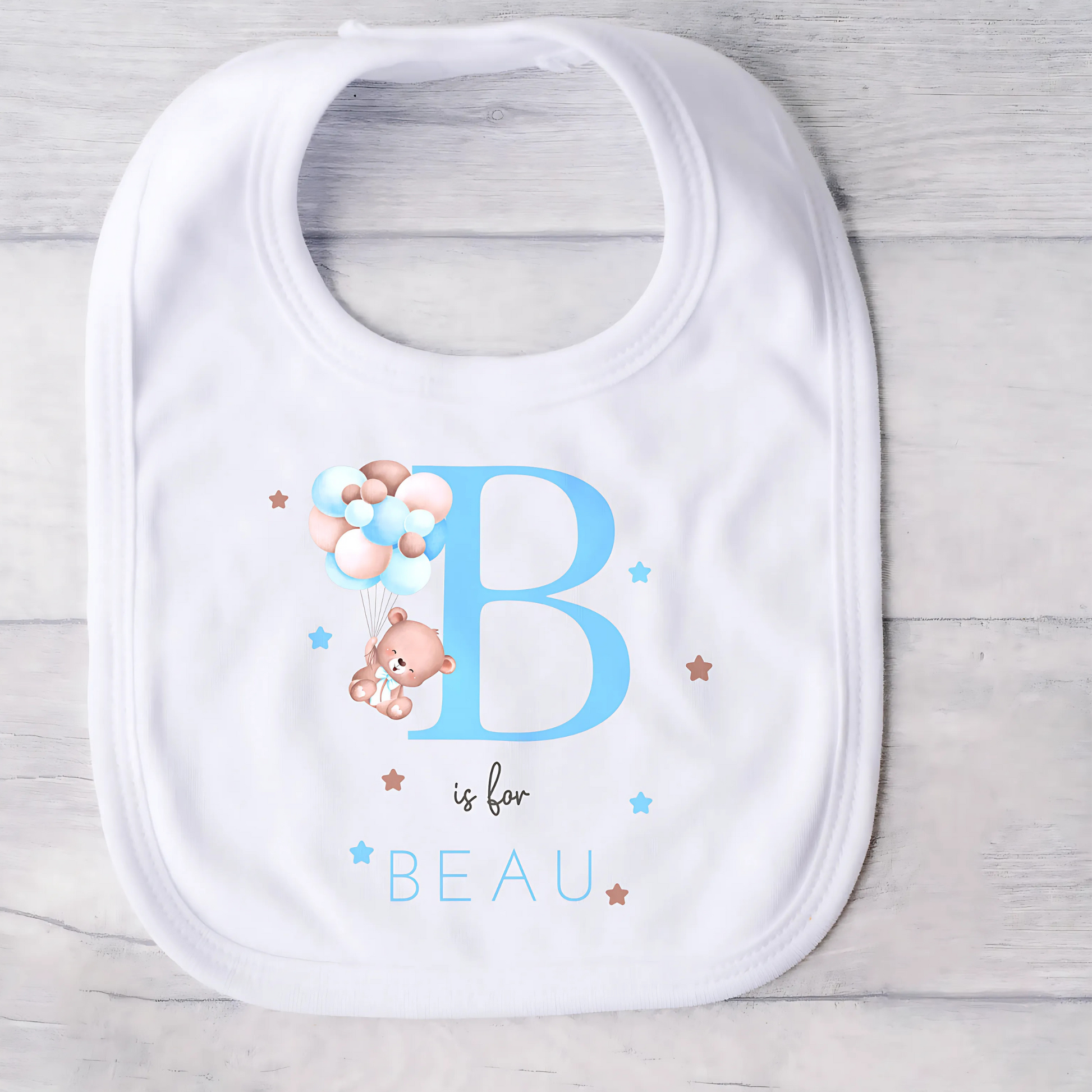 personalised baby outfit: A personalised baby boy outfit featuring a blue balloon bear design with baby name initial. Available as a sleepsuit, bodysuit, T-shirt, or bib, this charming new baby gift is perfect for a coming home outfit or gender reveal celebration.