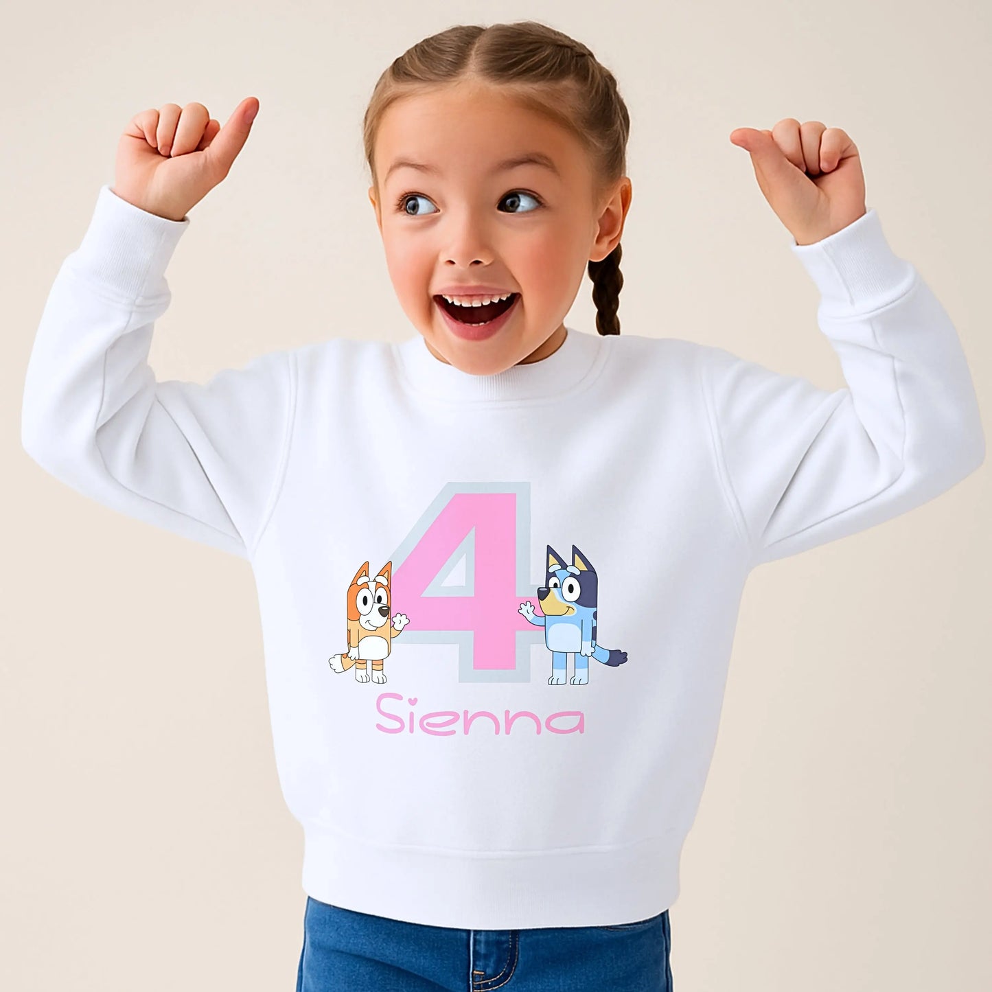 Persoalised Bluey and Bingo birthday sweatshirt: Child wearing a purple sweatshirt with bluey and bingo characters and her name underneath