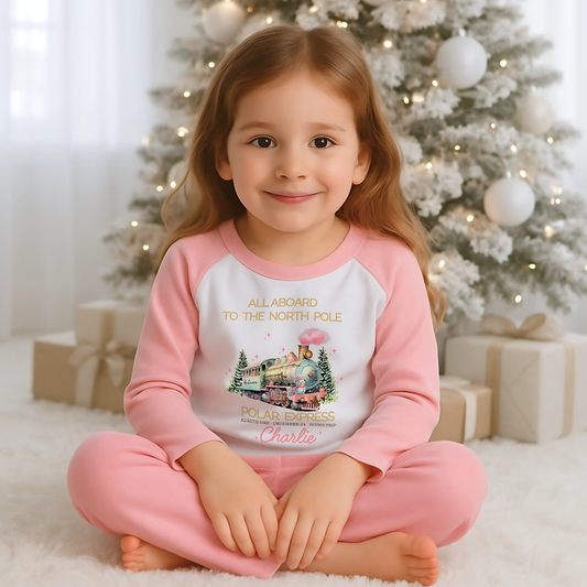 Polar express christmas pyjamas: A set of pink polar express Christmas Eve pyjamas for girls, personalised with a name. These pyjamas are designed to evoke the magic and wonder of the holiday season, made from soft, breathable fabric for a cozy night's sleep. Perfect for dreaming of a Polar Express journey to the North Pole. Girls polar express christmas pjs, christmas pyjamas personalised