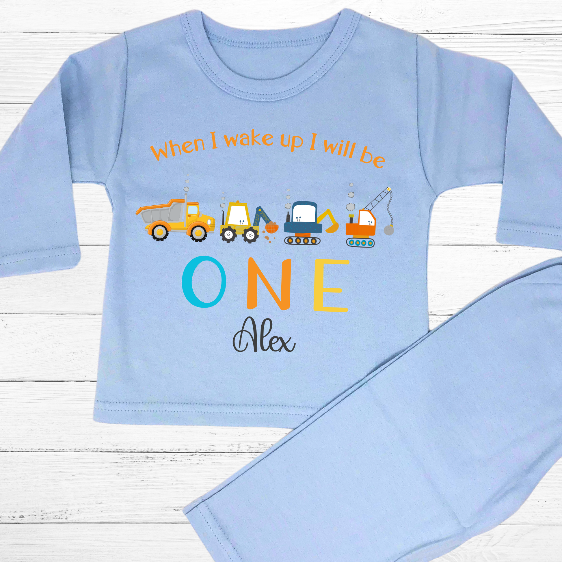 Personalised First Birthday pyjamas: personalised set of baby boy pyjamas for a first birthday,with a construction theme. The pyjamas display a playful design with diggers and excavators. The top reads: When I Wake Up I’ll Be ONE incorporating the child&#39;s name for a personalised touch. This set is ideal for toddlers who love construction vehicles, offering both comfort and a fun, imaginative theme: personalised baby pyjamas, first birthday, digger, excavator, custom name, construction vehicles.