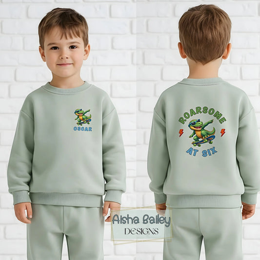 Personalised birthday loungewear set for boys with skateboard dinosaur design, custom name and age print, soft sweatshirt and matching bottoms for birthday celebrations