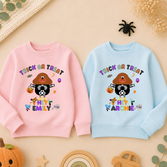 Flat lay of a personalised Halloween sweatshirt with trick-or-treat hey Duggee design and custom name