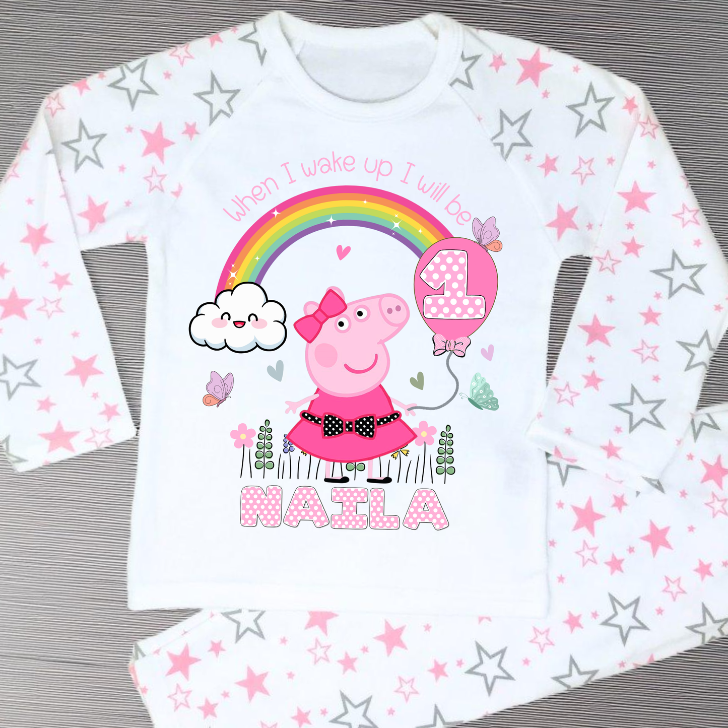 Peppa Pig birthday pyjamas: set of Personalised Peppa Pig Birthday Pyjamas designed for little girls, featuring Peppa Pig in a whimsical spring garden theme with blooming flowers and vibrant colours. The pyjamas include a playful rainbow with pink polka dots, displaying the child's age for a personalised touch. The set is personalised with the child's name, making it a unique gift for Peppa Pig fans, perfect for wearing on the eve of their birthday.