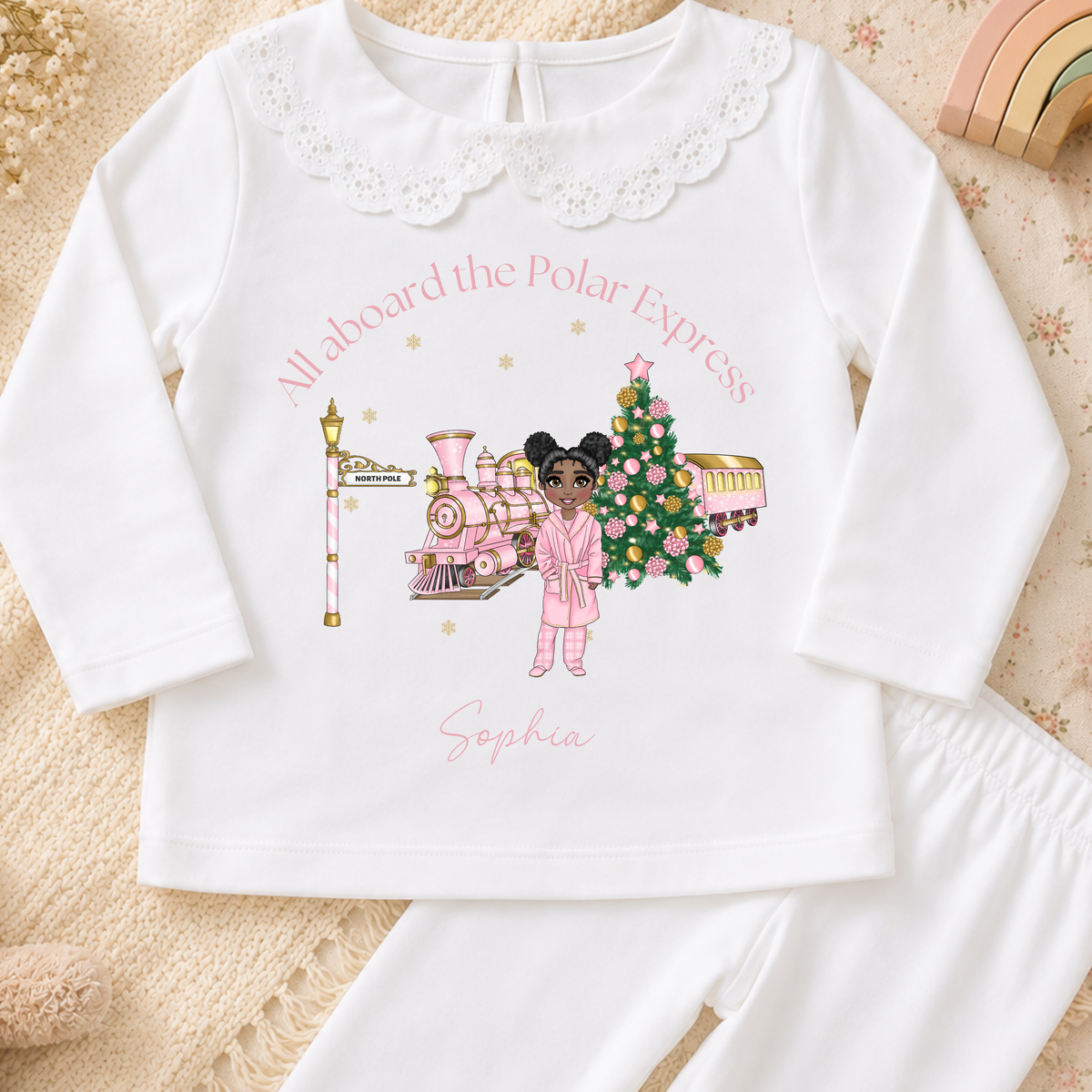 Personalised Christmas Pyjamas for girls with frill detail, custom name, Christmas doll, festive train and Christmas tree design.