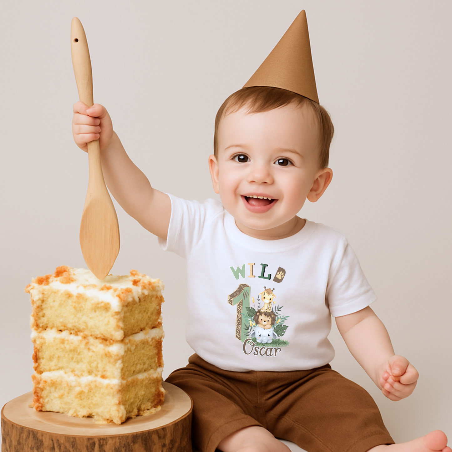 Wild One birthday t-shirt: A personalised Wild One 1st Birthday T-shirt for boys, featuring charming safari animals and vibrant colours. The shirt, designed for a jungle safari theme birthdays, includes space to customise with your child's name. Made from soft, high-quality materials, it promises comfort and style for your baby's first birthday celebration.