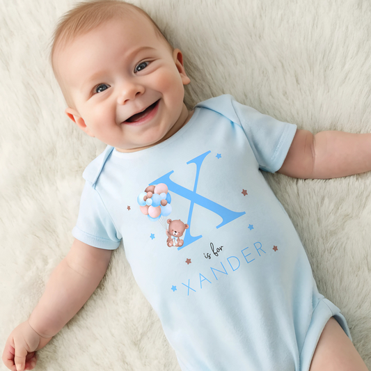 personalised baby outfit: A personalised baby boy outfit featuring a blue balloon bear design with baby name initial. Available as a sleepsuit, bodysuit, T-shirt, or bib, this charming new baby gift is perfect for a coming home outfit or gender reveal celebration.