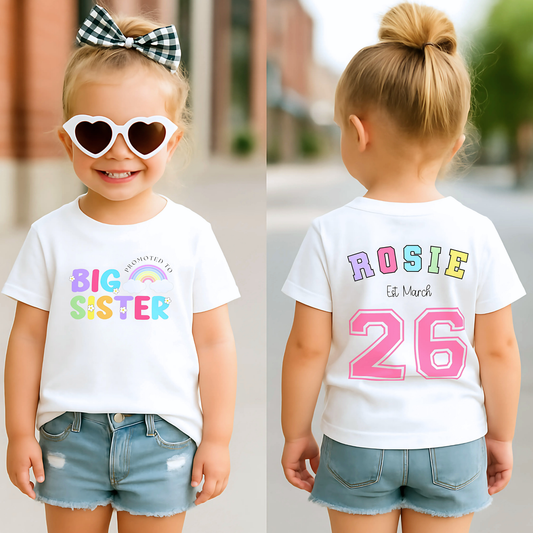 promoted to big sister t-shirt: A girls personalised promoted to big sister pregnancy announcement t-shirt featuring the phrase &quot;I am going to be a Big Sister&quot; in vibrant rainbow colours. This is designed to celebrate a big or bigger sister role.  Customisable with a special date, it serves as a keepsake for capturing precious sibling moments and marking the start of a new journey. Perfect for sharing the exciting news with family and the world. Matching Sibling, Big Sister Shirt