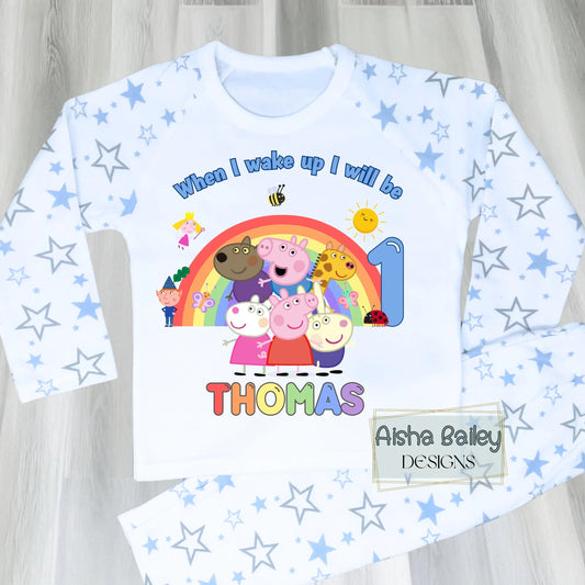 Blue Peppa Pig and friends personalised girls birthday pyjamas featuring a rainbow design and the text “When I wake up I will be with custom age and name, printed on a soft long-sleeve top and matching pink bottoms. Perfect personalised Peppa Pig birthday outfit for toddlers, ideal for first second third birthday celebrations, gifts, and bedtime photos.