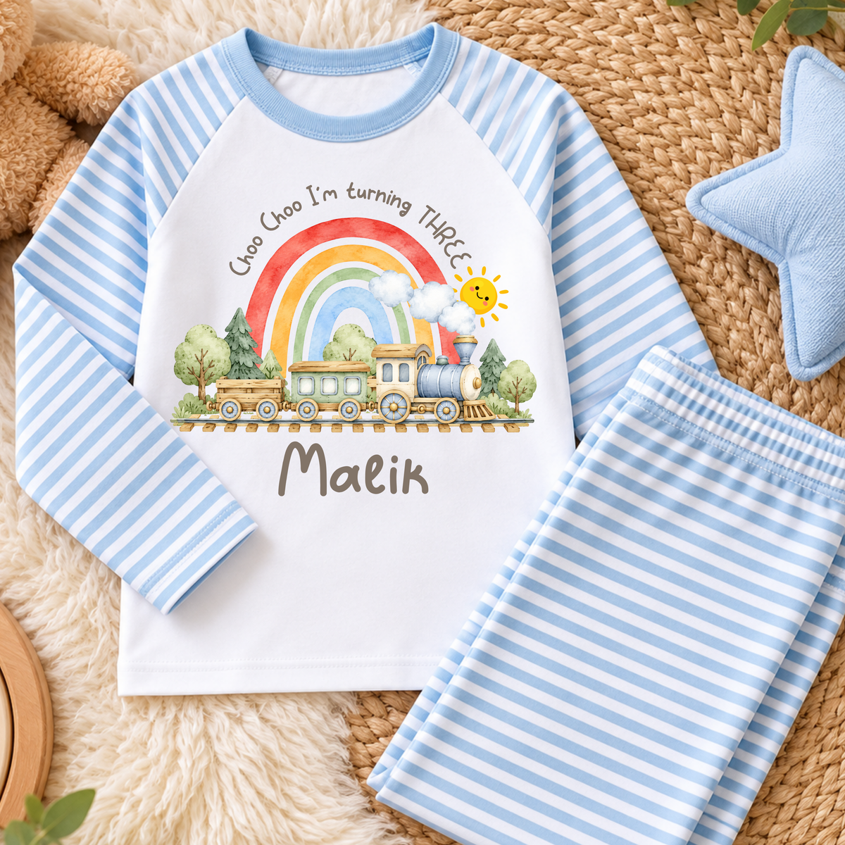 Personalised Train Birthday Two-Piece Set with watercolour steam train, rainbow, smiling sun and child's name. Available in sage green, beige and baby blue stripes.