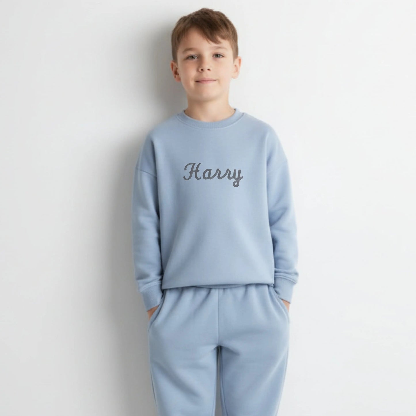 Personalised Embroidered Loungewear: A child wearing a two piece loungwear set with their name displayed on the front. Perfect for birthday and