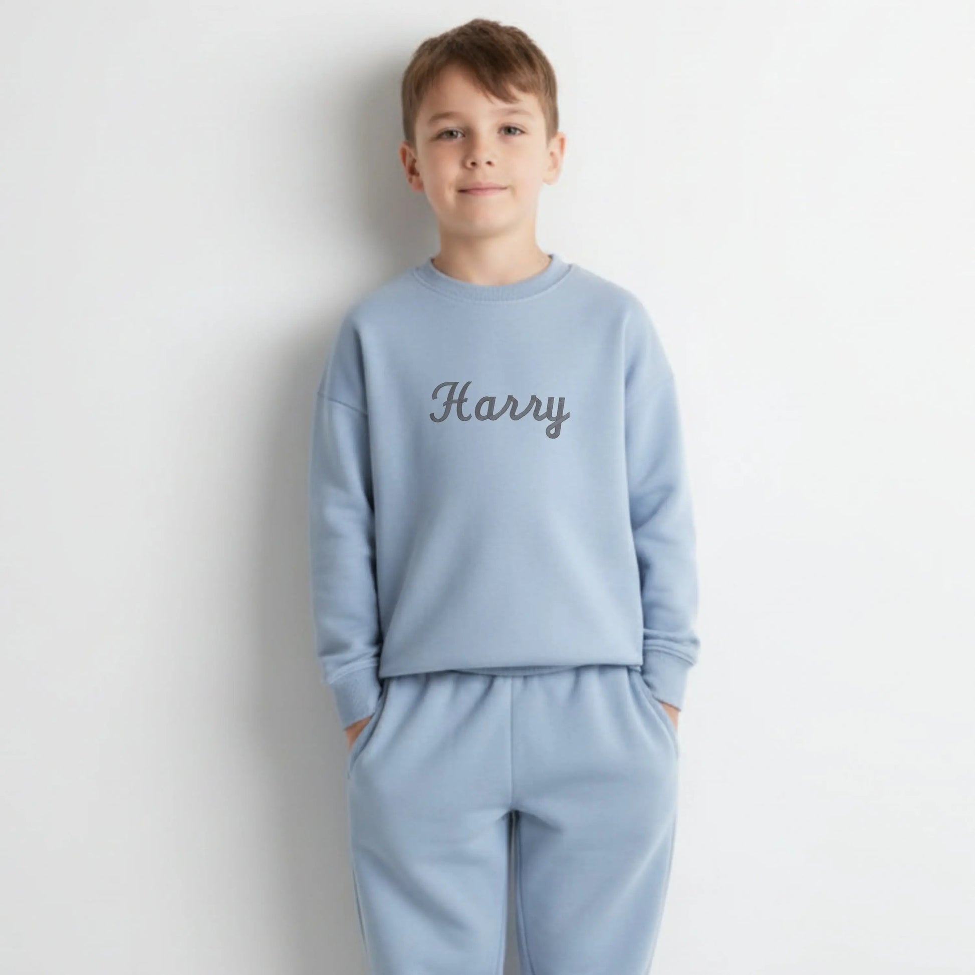 Personalised Embroidered Loungewear: A child wearing a two piece loungwear set with their name displayed on the front. Perfect for birthday and