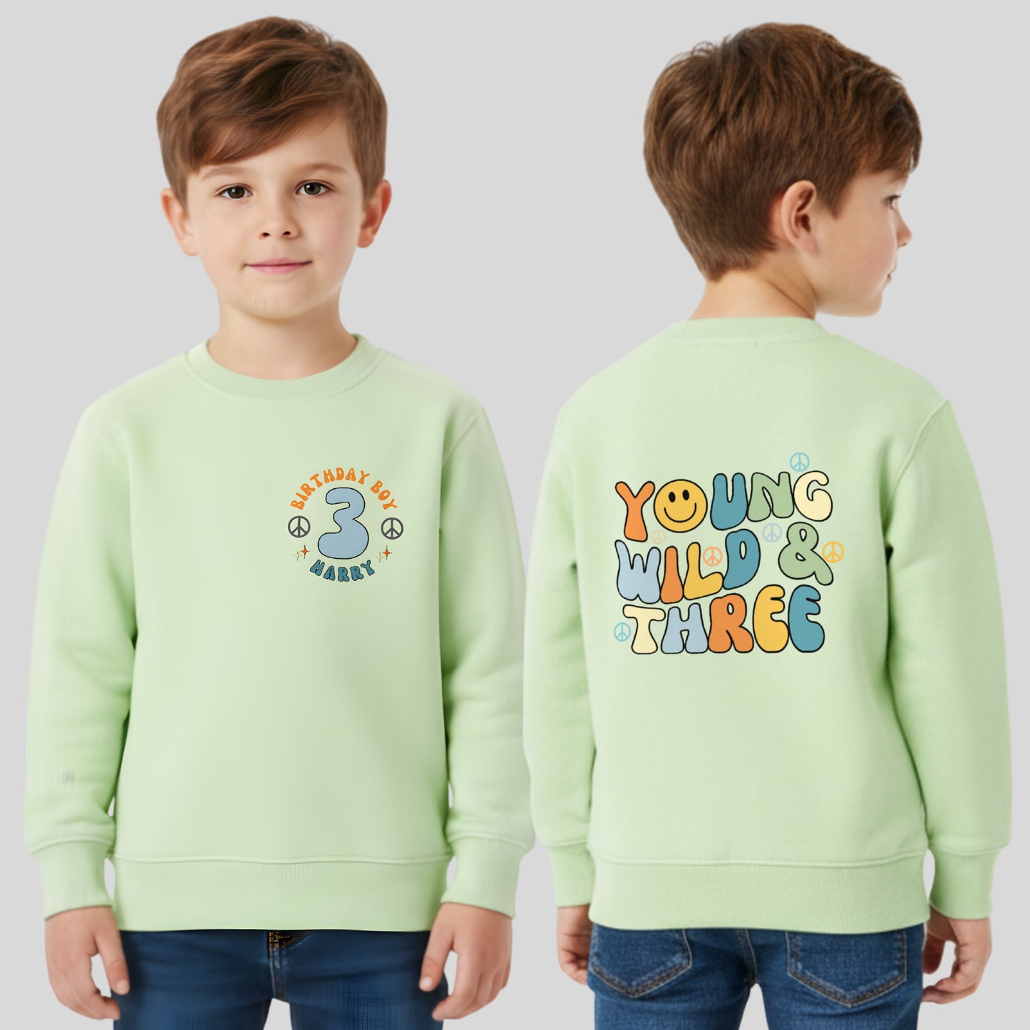 Personalised Young Wild and three birthday sweatshirt: A boys birthday sweatshirt with a Young Wild and Three theme, showcasing a groovy retro style. The front features whimsical retro emojis and the words birthday boy alongside a custom name on the left breast. The back displays bold retro fonts and graphics. Tthis vibrant and playful tee is designed for comfort and style, perfect for third birthday gifts.