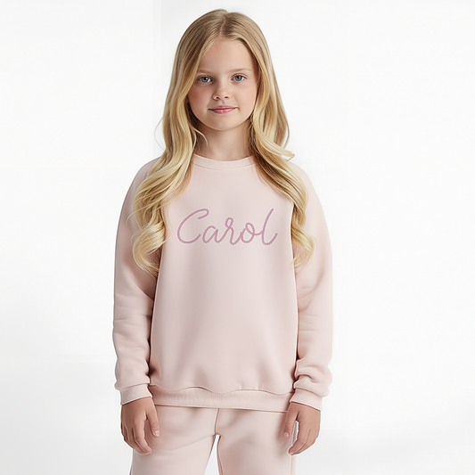 Personalised embroidered loungewear with a name: A child wearing a loungewear set with their name displayed on the front. Perfect for Christmas and birthday gifting