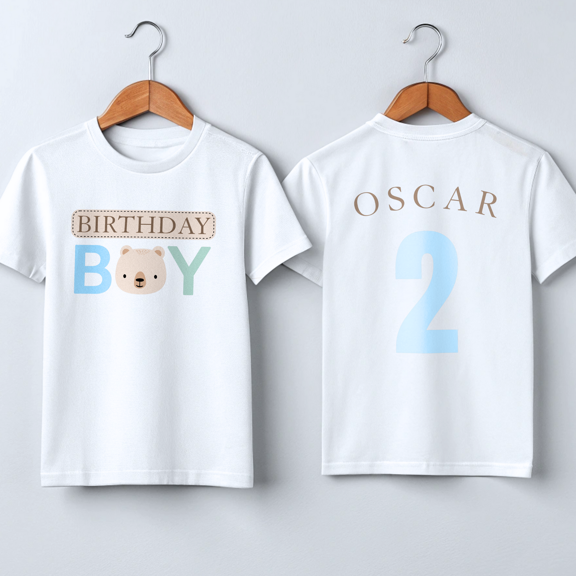 Teddy Bear Birthday T-shirt, Personalized Brown Bear Birthday T-Shirt: A charming white t-shirt showcasing a neutral theme with an adorable teddy bear head graphic and the words “Birthday Boy” in eye-catching beige, blue, and sage tones. The back is personalized with the child's name and age, making it the perfect birthday gift or celebration outfit for a toddler boy, ideal for memorable birthday photos and parties.