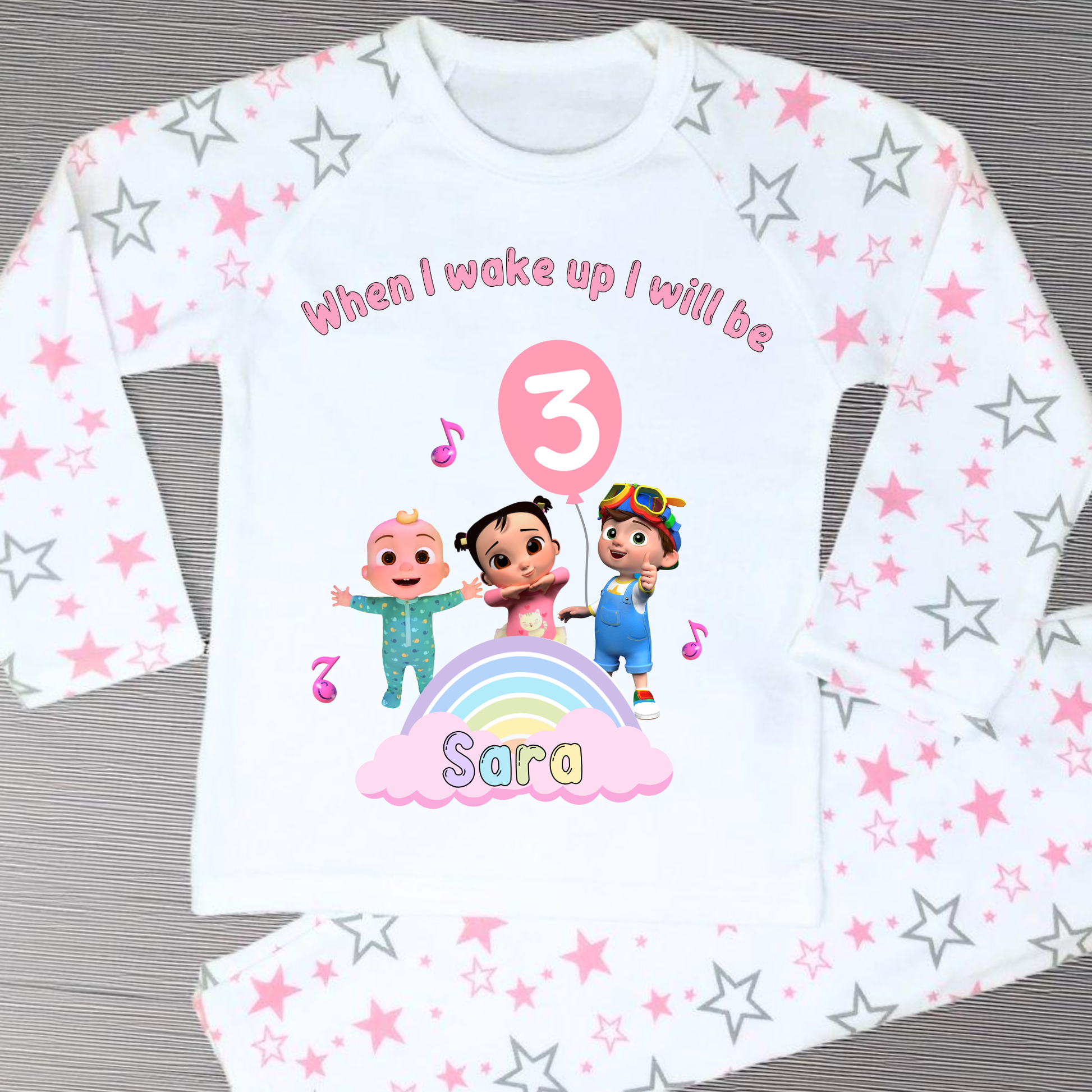 Cocomelon Birthday Pyjamas: Image of a set of Cocomelon Birthday Pyjamas for children, displayed on a soft, pastel-hued background. The pyjamas are made from a soft fabric and showcase a pastel rainbow color scheme, adorned with popular Cocomelon characters. The ensemble is designed to be both stylish and comfortable, making it perfect for birthday celebrations or a cosy night. The image emphasizes the playful and whimsical nature of the pyjamas, capturing the essence of fun for young fans of Cocomelon.