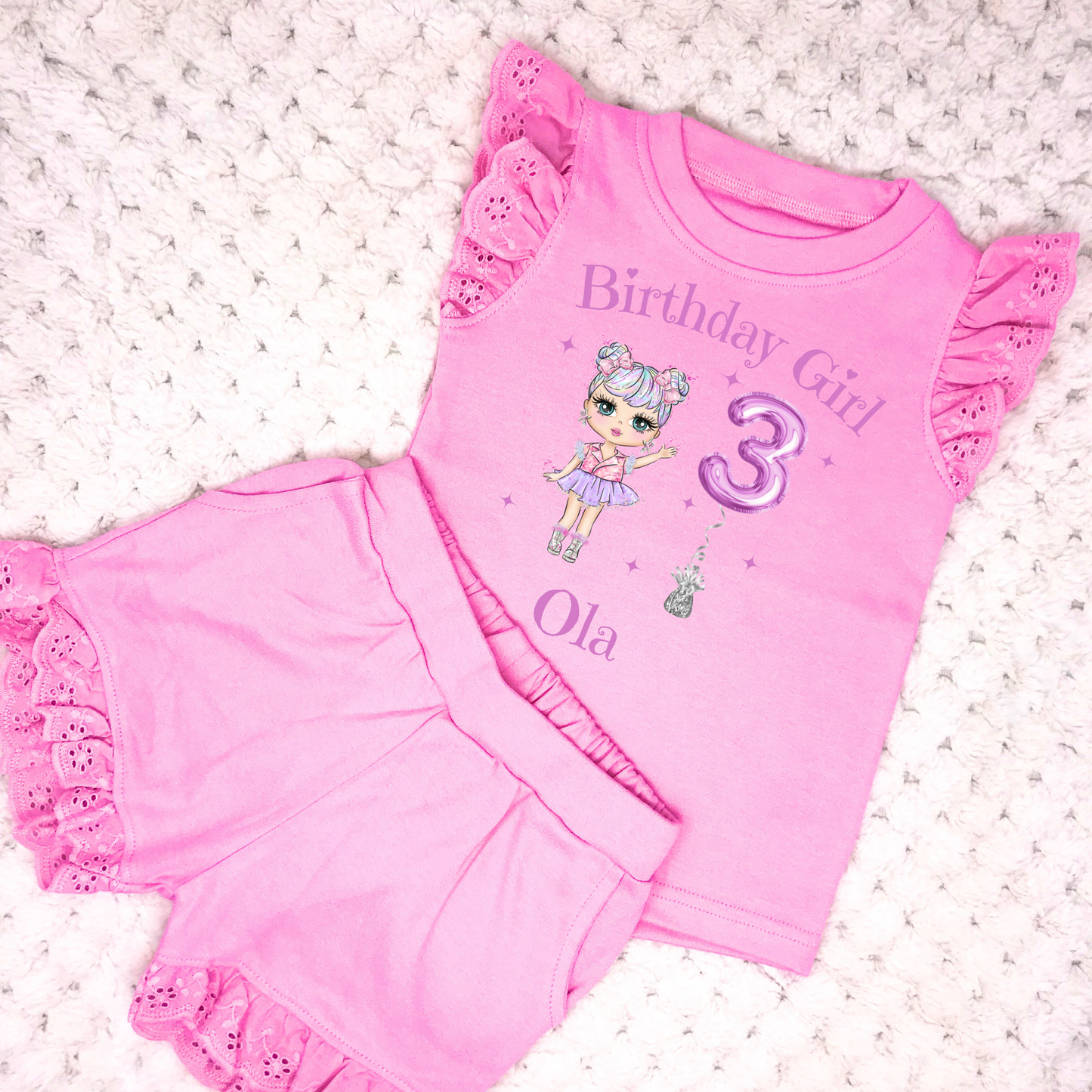 A vibrant and colourful personalised birthday outfit for girls, featuring a glitter-like design reminiscent of a pop star's ensemble. The set includes frilly shorts and a matching top, both adorned with rainbow hues, offering a playful and festive look. This personalised birthday girl outfit is perfect for a birthday celebration, capturing the spirit of fun and fashion. It also comes with a custom rainbow doll in the design, making it an ideal gift for young fashion enthusiasts.