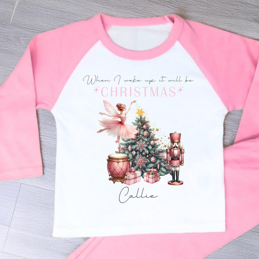 Girls personalised Christmas pyjamas featuring a beautifully illustrated ballerina as a Christmas fairy in dusky pink hues with nutcracker motifs in gold. These enchanting pyjamas offer a personalisation option to add a name, making them unique and ideal for gifting. Perfect for the Christmas season, they bring joy and become a treasured keepsake. Personalised Nutcracker Christmas Pyjamas, when i wake up it will be christmas
