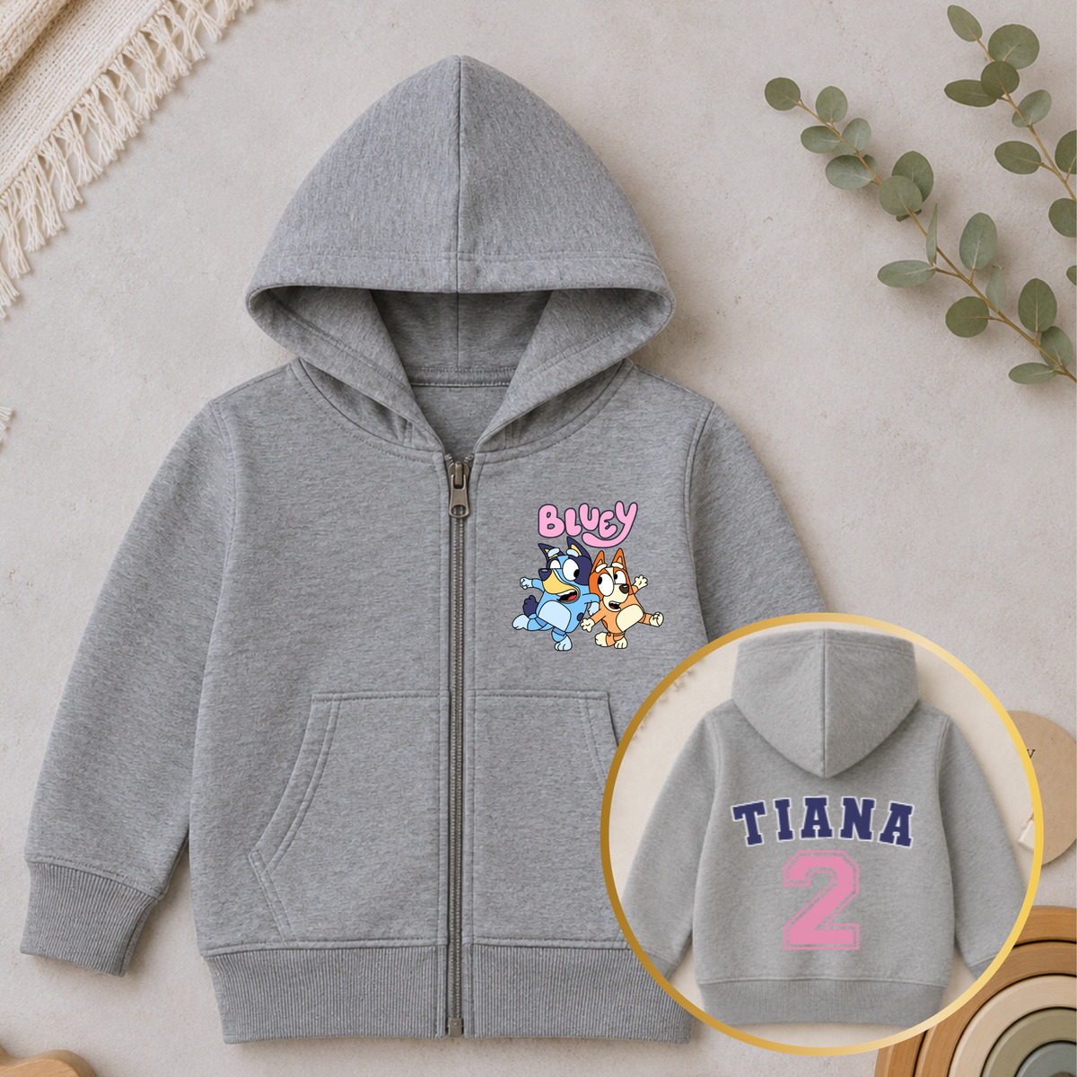 Personalised Girls Birthday Hoodie featuring Bluey and Bingo on the front, with your child's name and birthday age in a pink varsity-style design on the back.