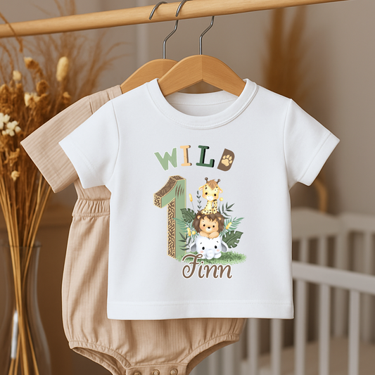 Wild One birthday t-shirt: A personalised Wild One 1st Birthday T-shirt for boys, featuring charming safari animals and vibrant colours. The shirt, designed for a jungle safari theme birthdays, includes space to customise with your child's name. Made from soft, high-quality materials, it promises comfort and style for your baby's first birthday celebration.