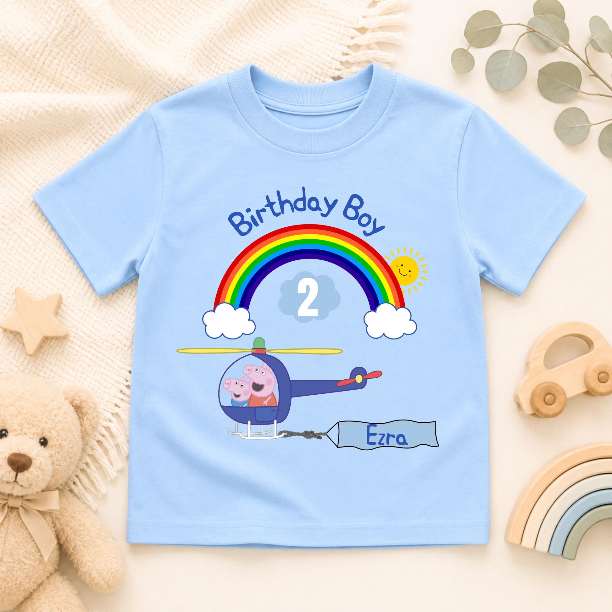 Personalised Peppa Pig and George birthday T-shirt for boys featuring a helicopter, rainbow, custom name Ezra and age 2 birthday design.
