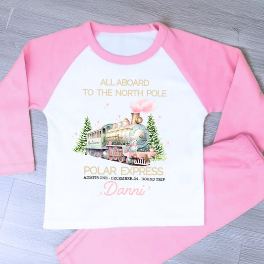 Polar express christmas pyjamas: A set of pink polar express Christmas Eve pyjamas for girls, personalised with a name. These pyjamas are designed to evoke the magic and wonder of the holiday season, made from soft, breathable fabric for a cozy night's sleep. Perfect for dreaming of a Polar Express journey to the North Pole. Girls polar express christmas pjs, christmas pyjamas personalised