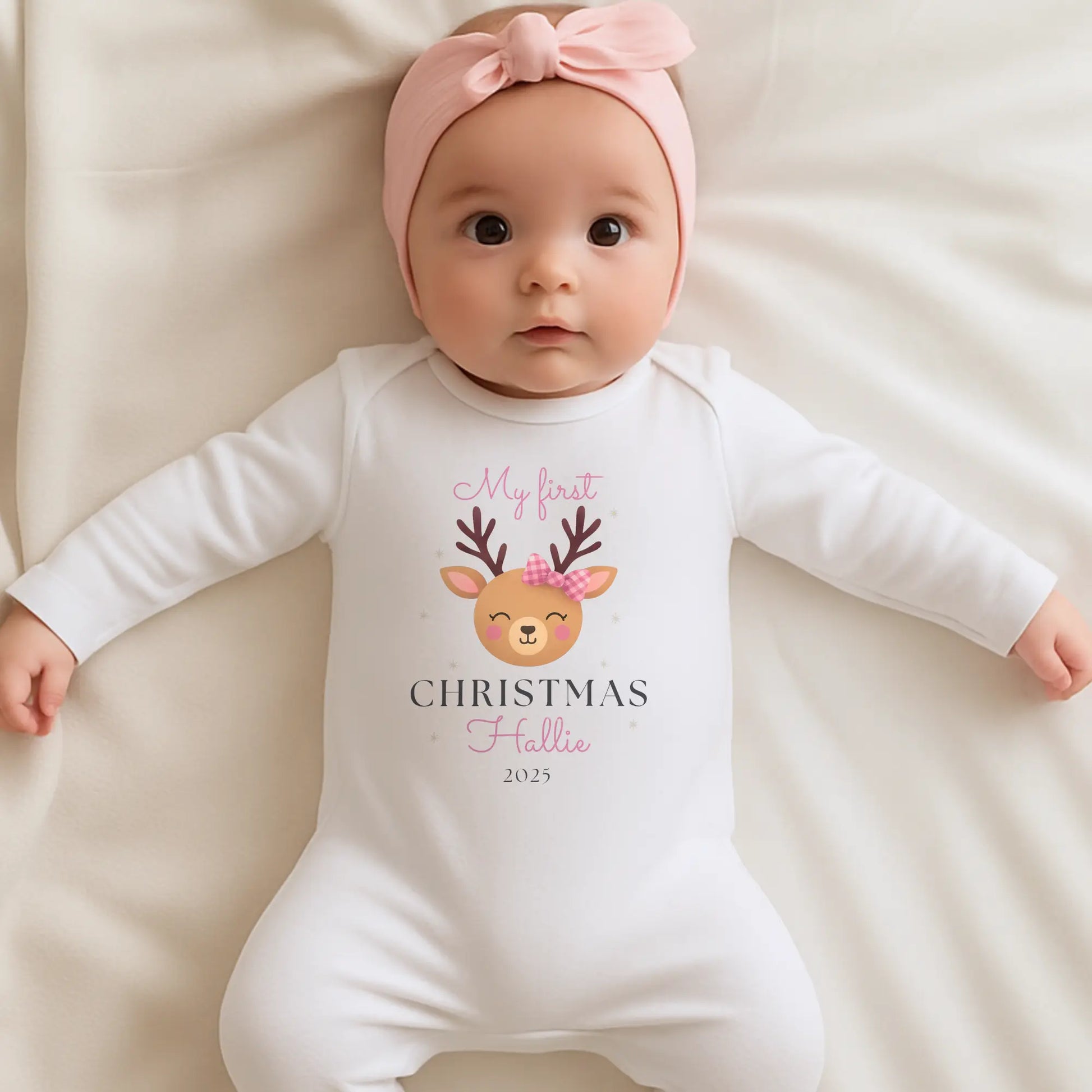Baby Girl’s 1st Christmas Outfit: Baby girl wearing a personalised 'My first Christmas' onesie with a deer design and pink bow.