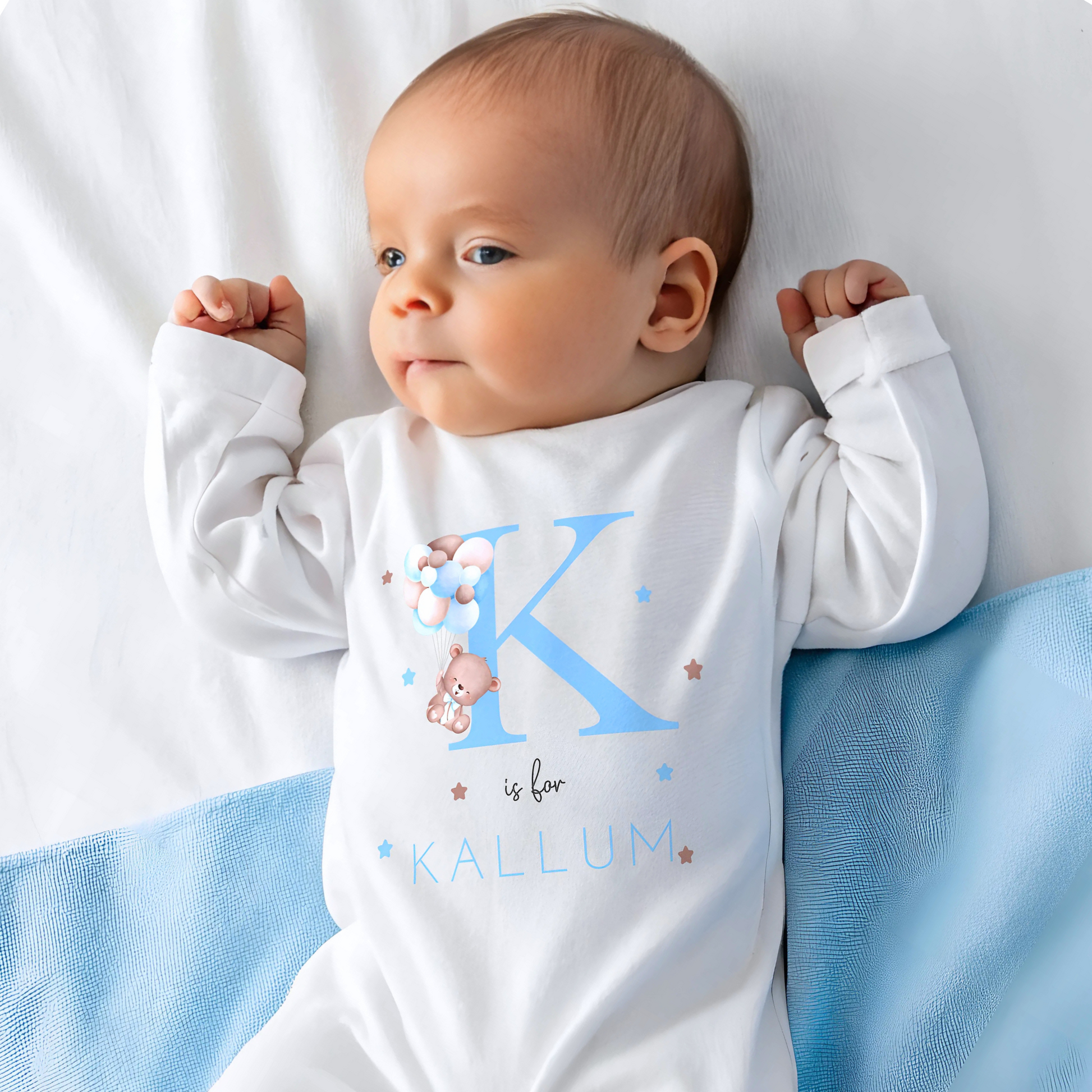 personalised baby outfit: A personalised baby boy outfit featuring a blue balloon bear design with baby name initial. Available as a sleepsuit, bodysuit, T-shirt, or bib, this charming new baby gift is perfect for a coming home outfit or gender reveal celebration.