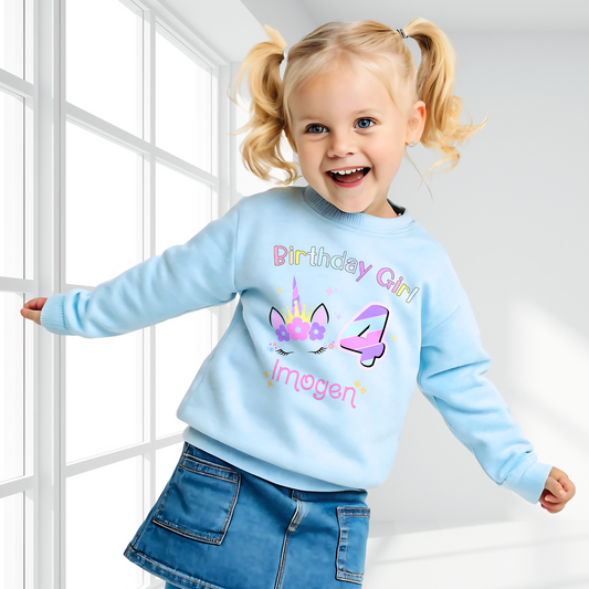 Unicorn Birthday Sweatshirt, A personalised birthday jumper for girls, featuring a pink and purple unicorn design. The sweatshirt is customisable with the child&#39;s name and age, making it a perfect birthday gift. The vibrant colours and whimsical unicorn imagery make it an ideal choice for a toddler celebrating her special day.