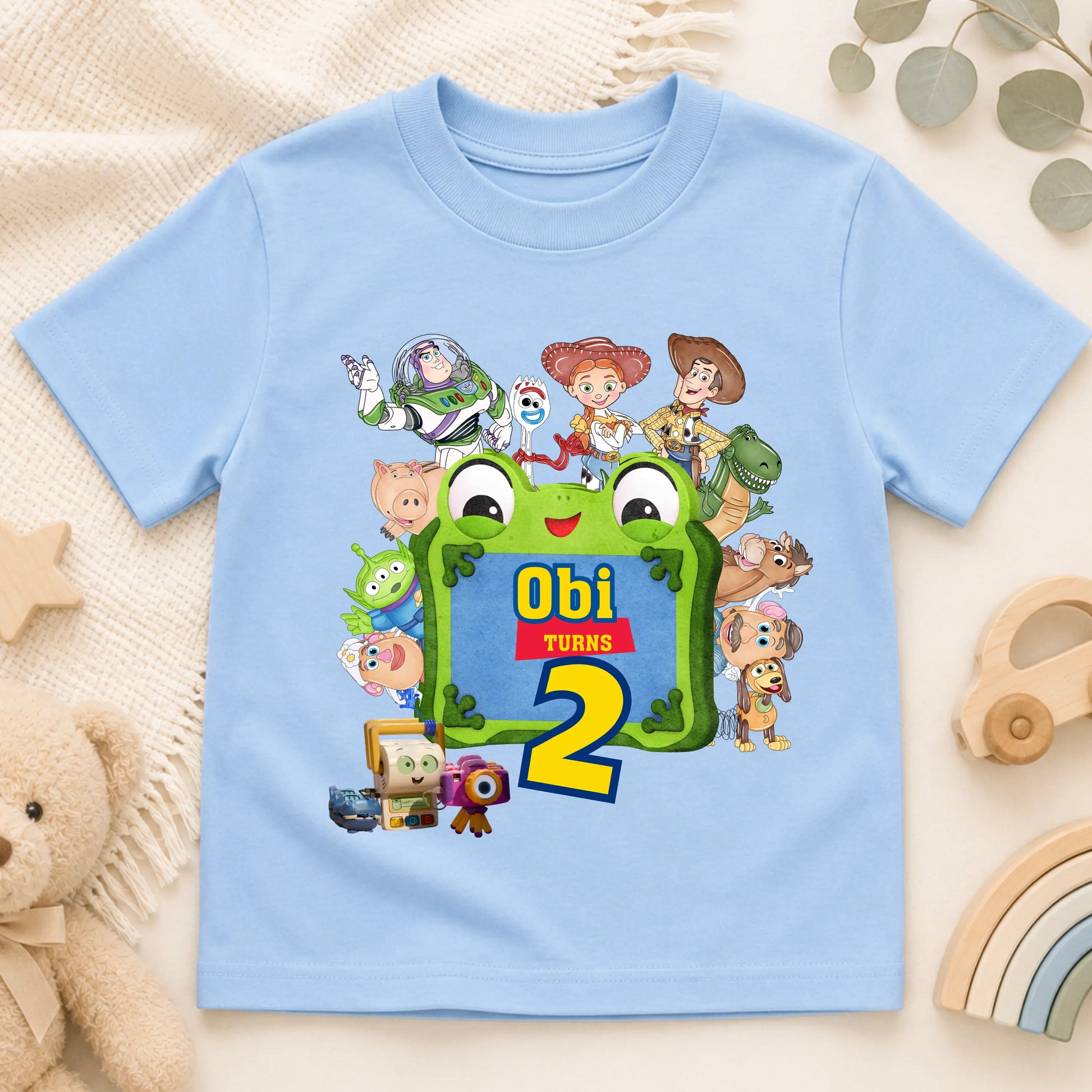 Personalised Toy Story birthday T-shirt for boys featuring custom name and age with colourful Toy Story-inspired characters including Buzz, Woody and friends, perfect for a birthday party outfit, cake smash and birthday photos.