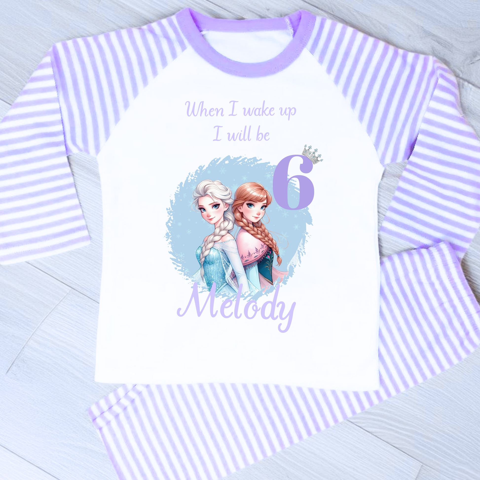 Personalised Frozen birthday pyjamas with name and age. Features Elsa and Anna in Frozen colours of blue and lilac. Perfect for birthday morning photos and celebrations.
