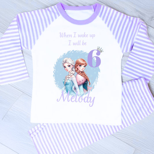 Personalised Frozen birthday pyjamas with name and age. Features Elsa and Anna in Frozen colours of blue and lilac. Perfect for birthday morning photos and celebrations.