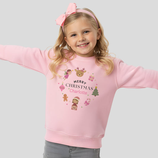personalised christmas sweatshirt: Child wearing a pink personalised Christmas-themed sweatshirt with decorative elements on a light gray background.