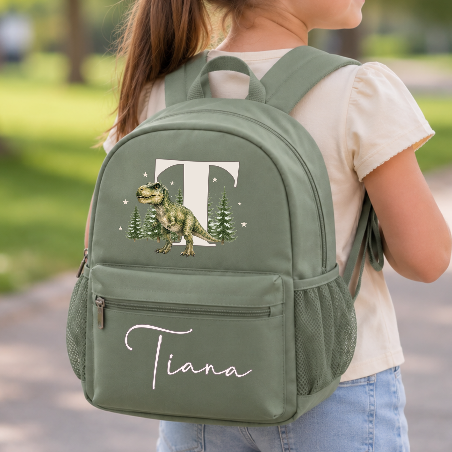 Personalised dinosaur backpack for boys with realistic watercolour T-Rex, woodland initial and custom name on sage, beige and blue school rucksack.
