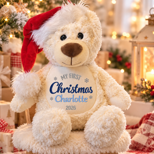 Personalised First Christmas Teddy Bear for baby with embroidered name, sparkling glitter vinyl Christmas design, soft cream fur and festive red Santa hat.