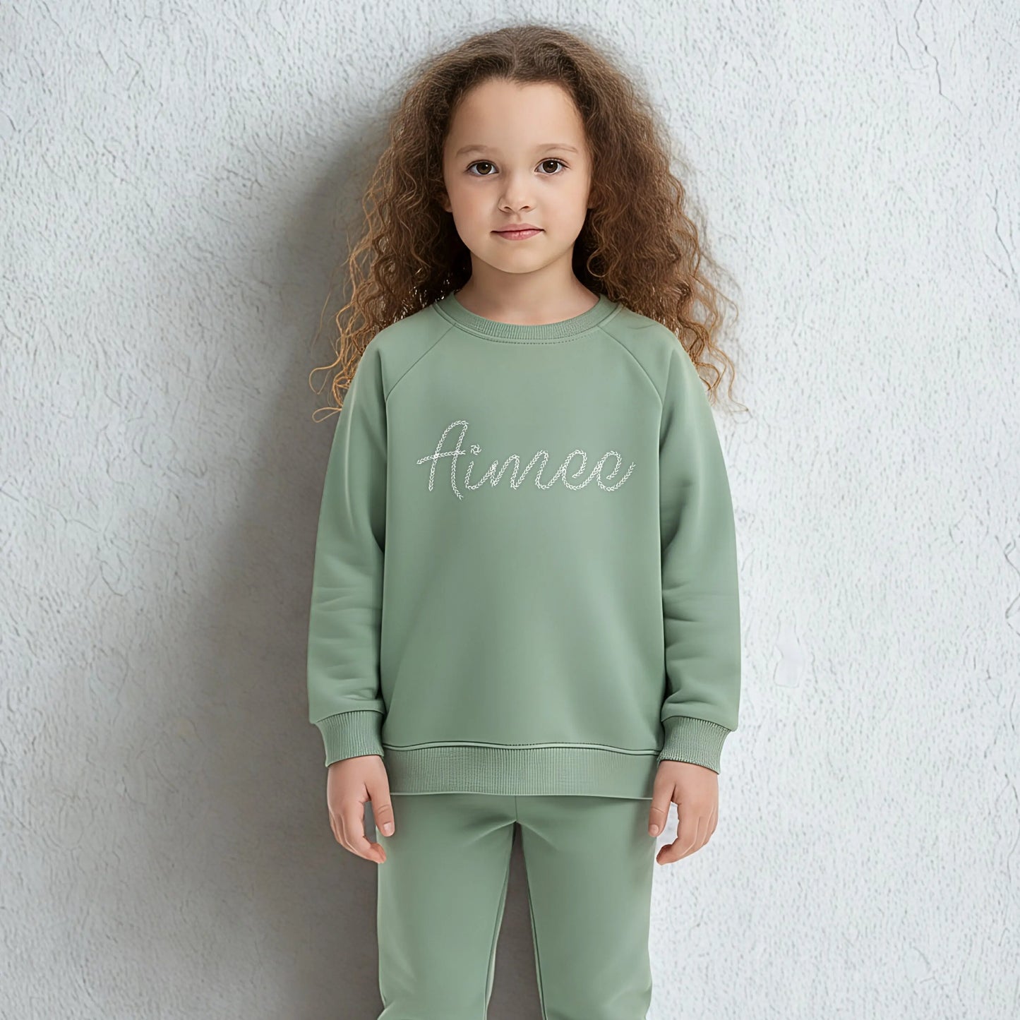 Personalised embroidered loungewear with a name: A child wearing a loungewear set with their name displayed on the front. Perfect for Christmas and birthday gifting