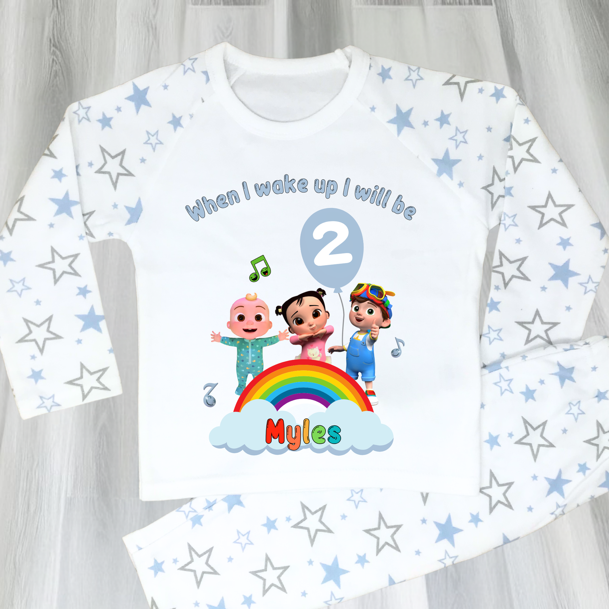 Cocomelon Birthday Pyjamas: Image of a set of Cocomelon Birthday Pyjamas for children, displayed on a soft, pastel-hued background. The pyjamas are made from a soft fabric and showcase a pastel rainbow color scheme, adorned with popular Cocomelon characters. The ensemble is designed to be both stylish and comfortable, making it perfect for birthday celebrations or a cosy night. The image emphasizes the playful and whimsical nature of the pyjamas, capturing the essence of fun for young fans of Cocomelon.