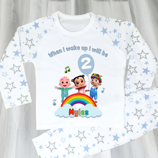 Cocomelon Birthday Pyjamas: Image of a set of Cocomelon Birthday Pyjamas for children, displayed on a soft, pastel-hued background. The pyjamas are made from a soft fabric and showcase a pastel rainbow color scheme, adorned with popular Cocomelon characters. The ensemble is designed to be both stylish and comfortable, making it perfect for birthday celebrations or a cosy night. The image emphasizes the playful and whimsical nature of the pyjamas, capturing the essence of fun for young fans of Cocomelon.