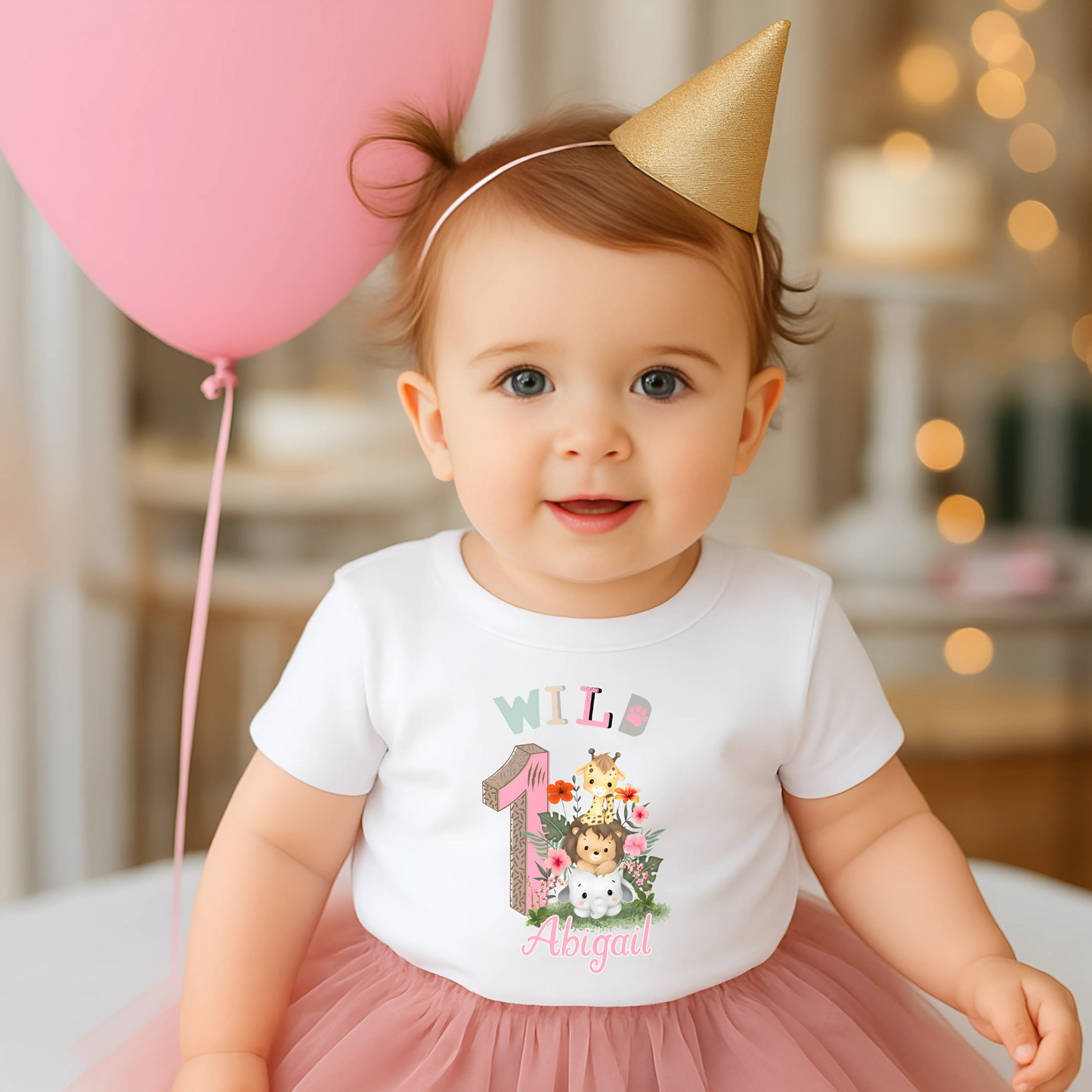 Wild One birthday t-shirt: A personalised Wild One 1st Birthday T-shirt for girls, featuring charming safari animals and vibrant colours. The shirt, designed for a jungle safari theme birthdays, includes space to customise with your child's name. Made from soft, high-quality materials, it promises comfort and style for your baby's first birthday celebration.
