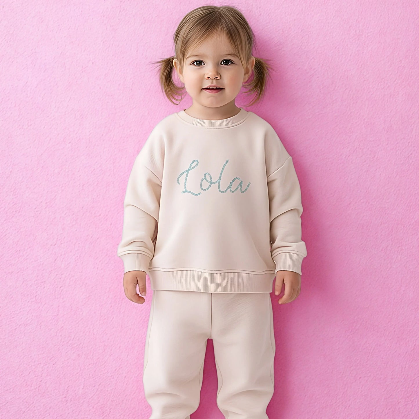 Personalised embroidered loungewear with a name: A child wearing a loungewear set with their name displayed on the front. Perfect for Christmas and birthday gifting