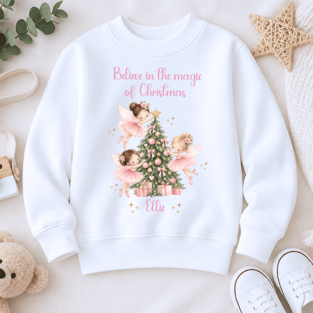 Personalised Christmas sweatshirt for girls featuring magical pink fairies decorating a Christmas tree, customised with the child’s name.