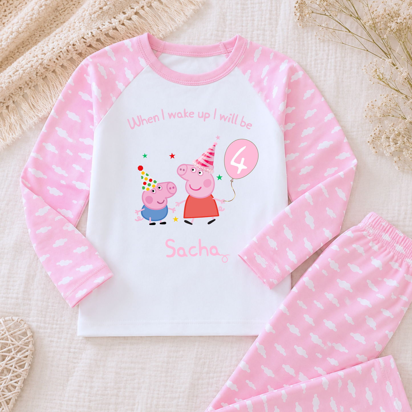 Girls Personalised Peppa and George Pig Birthday Pyjamas, Peppa Pig Personalised Pyjamas, When I wake Up I'll Be Pj's, Girls Peppa Pig Pjs, Peppa Pig Birthday Gift, Name Pyjamas, Happy Birthday Pjs, A children's two-piece pajama set laid flat on a textured cream fabric background. The long-sleeve top is white with pink sleeves and a pink pattern, featuring a Peppa Pig birthday graphic with the text 'When I wake up I will be Sacha' and a '4' balloon.