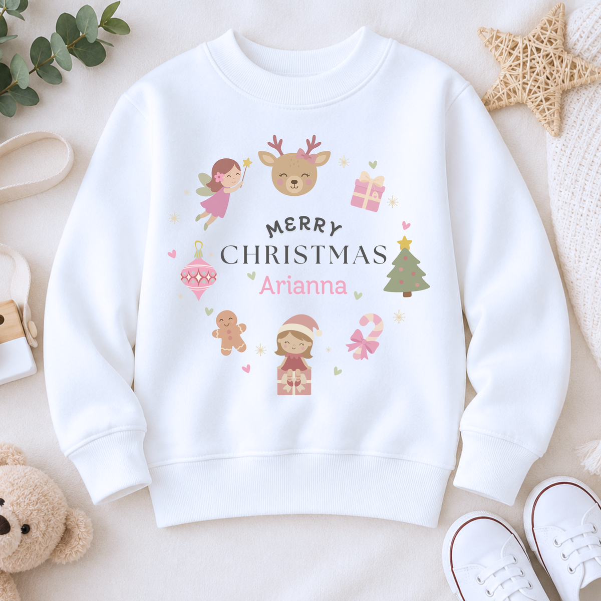 personalised christmas sweatshirt: Child wearing a pink personalised Christmas-themed sweatshirt with decorative elements on a light gray background.